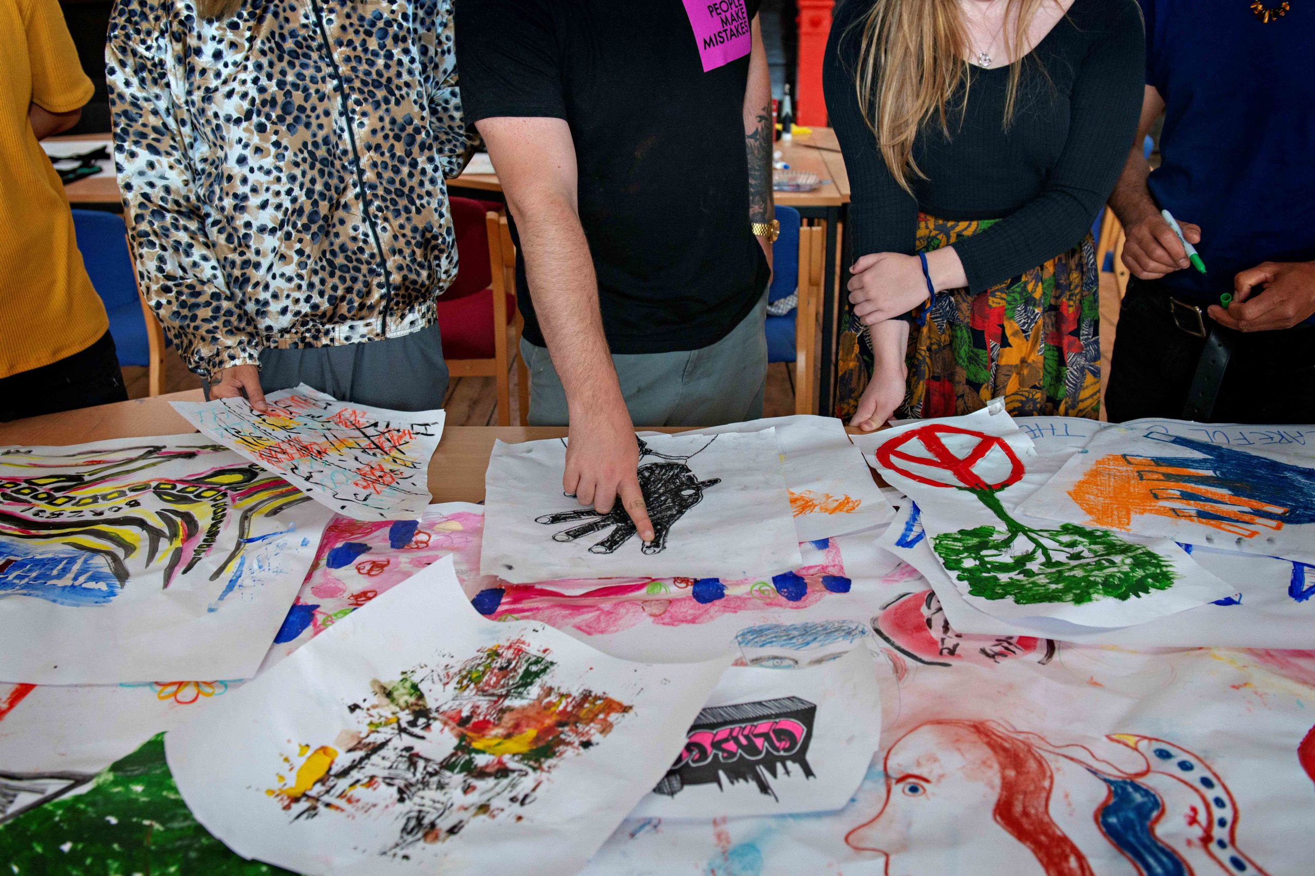 People looking at drawings on a table.